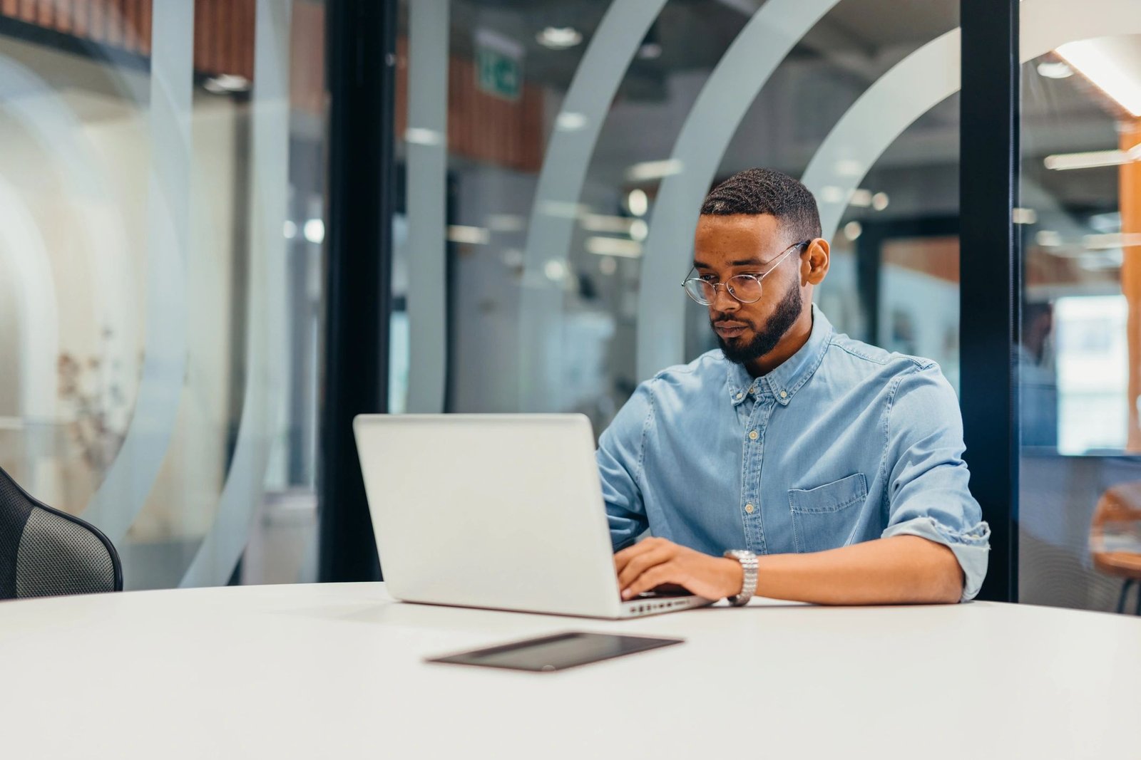 IT professional working on a laptop in a modern office